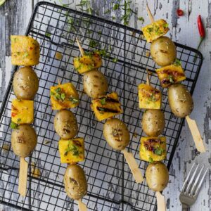 Brochette van gegrilde krielaardappelstjes en pittig gemarineerde ananas.