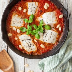 Traag gegaarde kabeljauw in een voedzame tomatensaus met amandelen